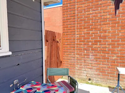 a chair sitting next to a brick wall with a table at Little Betty's Casita in Torrance