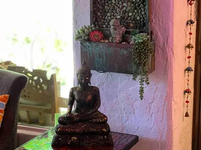 a statue sitting on a table next to a wall at Boho Chic Malibu Retreat Estate Salt Pool + Yoga in Malibu