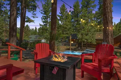 a patio with two red chairs and a fire pit at Mountain Getaway in Big Bear Lake