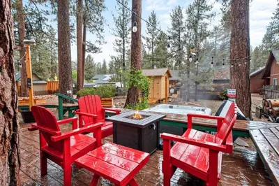 a patio with two red chairs and a fire pit at Mountain Getaway in Big Bear Lake