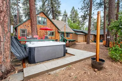 a house with a hot tub in front of a house at Mountain Getaway in Big Bear Lake