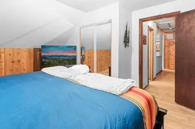 a bedroom with a large bed with a blue blanket at Mountain Getaway in Big Bear Lake