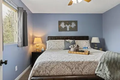 a bedroom with a bed with blue walls and a window at Panoramic Views at Deer Crest Lodge in Lake Arrowhead