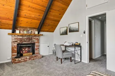 a living room with a fireplace and a table at Brunos Bungalow in Big Bear Lake