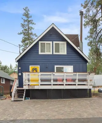 a blue house with a white porch in front of it at Brunos Bungalow in Big Bear Lake