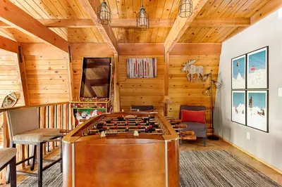 a living room with a foosball table in the center at The 99 Pines Walk to Snow Summit Hot Tub in Big Bear Lake