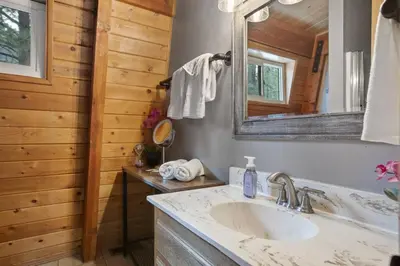 a bathroom with a sink and a mirror at The 99 Pines Walk to Snow Summit Hot Tub in Big Bear Lake