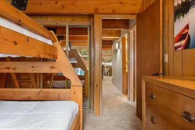 a bedroom with a bunk bed and a staircase at The 99 Pines Walk to Snow Summit Hot Tub in Big Bear Lake
