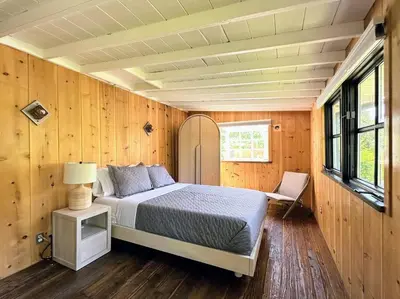 a bedroom with a bed and a chair in a room at Malibou Lake Oasis in Agoura Hills
