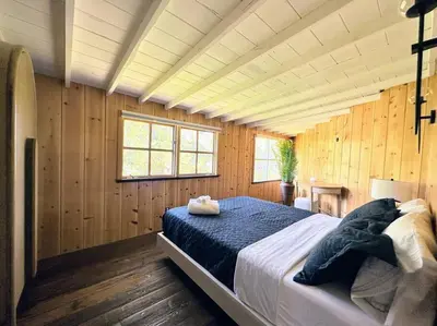 a bedroom with a large bed in a room with wooden walls at Malibou Lake Oasis in Agoura Hills