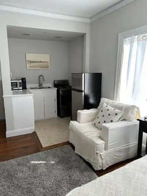a living room with a white couch and a kitchen at The Vurpillat in Hermosa Beach