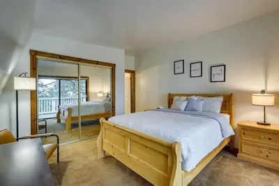 a bedroom with a large bed and a mirror at The Abby Cabin Restful Running Springs Retreat! in Running Springs