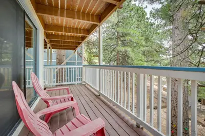 two red chairs sitting on the porch of a house at The Abby Cabin Restful Running Springs Retreat! in Running Springs