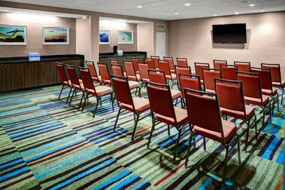 a conference room with red chairs and a flat screen tv at Fairfield Inn & Suites by Marriott Los Angeles LAX/El Segundo in El Segundo