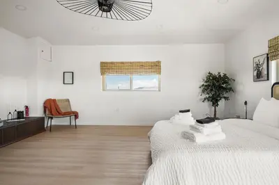 a white bedroom with a bed and a window at Luxury 6BR Retreat Fast WIFI, Dedicated Workspaces in Hesperia