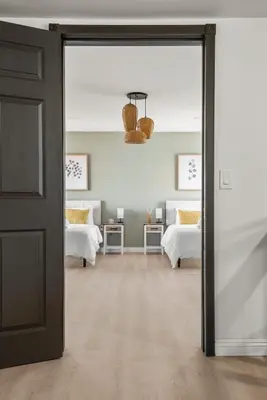 an open door into a bedroom with two beds at Luxury 6BR Retreat Fast WIFI, Dedicated Workspaces in Hesperia