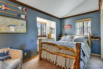 a bedroom with a bed and a blue wall at Central Big Bear Lake Retreat with Private Hot Tub! in Big Bear Lake