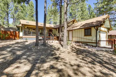 a house in the woods with trees in front of it at Central Big Bear Lake Retreat with Private Hot Tub! in Big Bear Lake