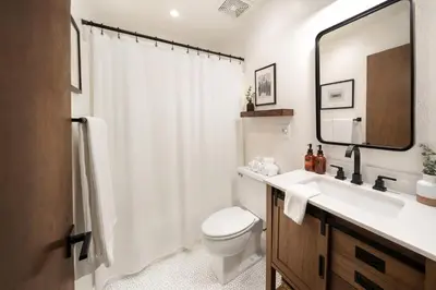 a bathroom with a toilet and a sink and a mirror at Large A-Frame Cabin (9 Beds, AC, + Lake Access) in Lake Arrowhead