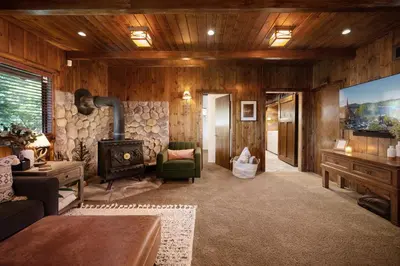 a living room with a fireplace and a stove at Large A-Frame Cabin (9 Beds, AC, + Lake Access) in Lake Arrowhead