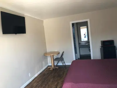 a bedroom with a bed and a table and a television at Star Motel in Norwalk