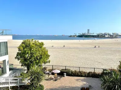 a view of a beach with people in the water at Beautiful Bright Condo Steps Away from the Beach in Long Beach