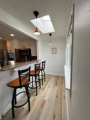 a kitchen with four chairs and a table in a room at Modern 3 King Beds, Beautiful Large Backyard, WFH, Long Stays, Waterfall, WI-FI, FWY, 25 mins to Beach in Thousand Oaks