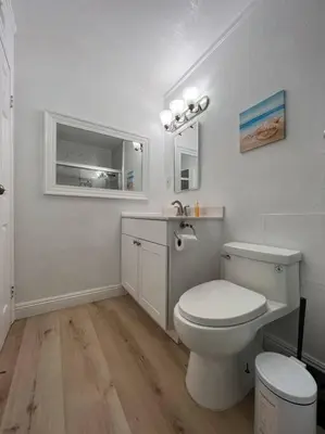 a white bathroom with a toilet and a sink at Modern 3 King Beds, Beautiful Large Backyard, WFH, Long Stays, Waterfall, WI-FI, FWY, 25 mins to Beach in Thousand Oaks