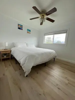 a white bedroom with a bed and a ceiling fan at Modern 3 King Beds, Beautiful Large Backyard, WFH, Long Stays, Waterfall, WI-FI, FWY, 25 mins to Beach in Thousand Oaks