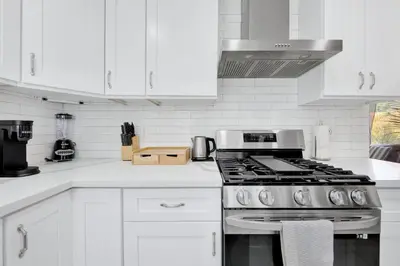 a white kitchen with a stove and white cabinets at Modern Peaceful Private Oasis Near The Beach in Los Angeles