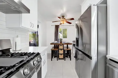 a kitchen with white cabinets and a stainless steel refrigerator at Modern Peaceful Private Oasis Near The Beach in Los Angeles
