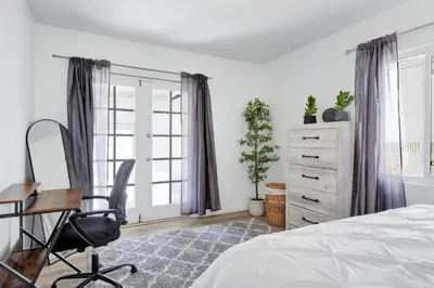 a bedroom with a bed and a desk and a chair at Modern Peaceful Private Oasis Near The Beach in Los Angeles