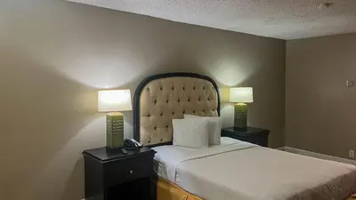 a bedroom with a bed with two lamps and a phone at Motel 6 Victorville Green Tree Bvld in Victorville