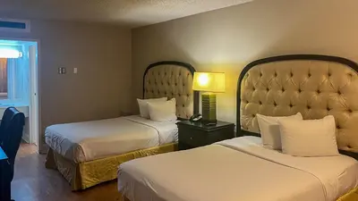 a hotel room with two beds and a lamp at Motel 6 Victorville Green Tree Bvld in Victorville