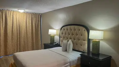 a bedroom with a large bed with two lamps on tables at Motel 6 Victorville Green Tree Bvld in Victorville