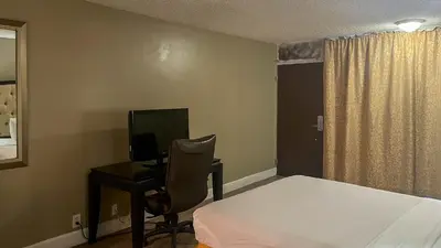 a bedroom with a bed and a desk with a computer at Motel 6 Victorville Green Tree Bvld in Victorville