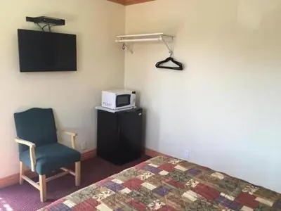 a bedroom with a bed and a tv and a chair at TRAVEL INN MOTEL in Los Angeles
