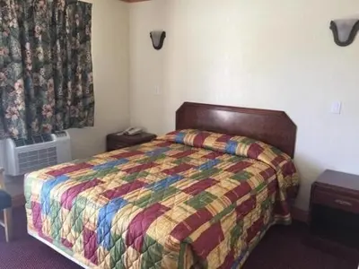 a bedroom with a bed with a colorful comforter at TRAVEL INN MOTEL in Los Angeles