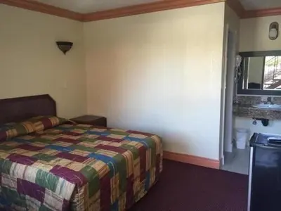 a bedroom with a bed and a window at TRAVEL INN MOTEL in Los Angeles