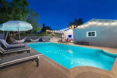 a swimming pool with two chairs and an umbrella at Angel&Rose Universal Hollywood Heated Pool House King Bed in Los Angeles