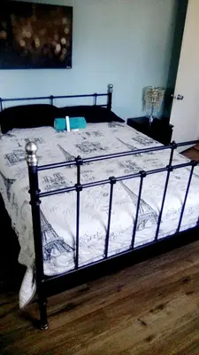 a bed with a black frame and white sheets at Los Angeles Zen Home in Los Angeles