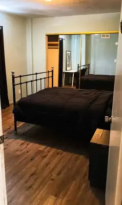 a bedroom with a black bed and a wooden floor at Los Angeles Zen Home in Los Angeles