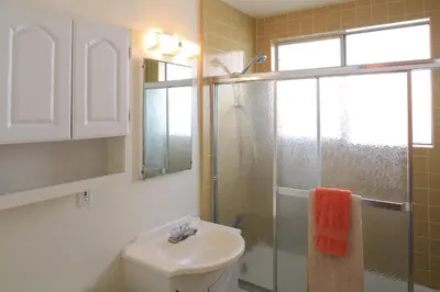 a bathroom with a toilet and a sink and a shower at Peninsula Hideaway Apartment • Alamitos Bay in Long Beach