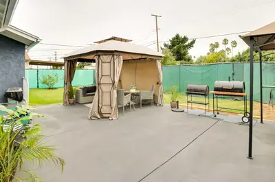 a patio with an umbrella and a table and chairs at Centrally Located Compton Retreat Patio and Grills in Compton