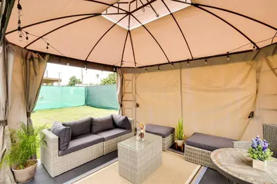 a patio with a couch and an umbrella at Centrally Located Compton Retreat Patio and Grills in Compton