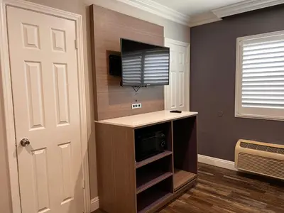 a living room with a flat screen tv on a wall at The Patio Motel - Los Angeles, LAX in Gardena