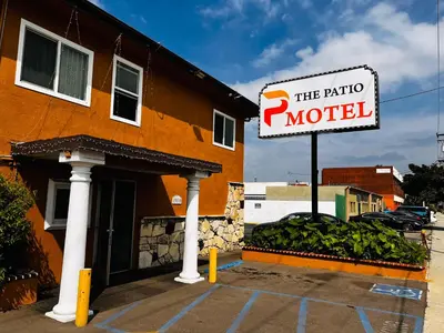 a sign in front of a building with a hotel at The Patio Motel - Los Angeles, LAX in Gardena