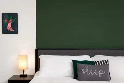 a bedroom with a green wall and a bed with white pillows at Fenix Hotel Hollywood in Los Angeles