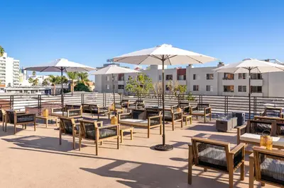 a group of tables and chairs with umbrellas at Fenix Hotel Hollywood in Los Angeles