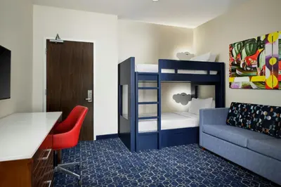 a small room with a bunk bed and a couch at SpringHill Suites by Marriott at Anaheim Resort Area/Convention Center in Anaheim